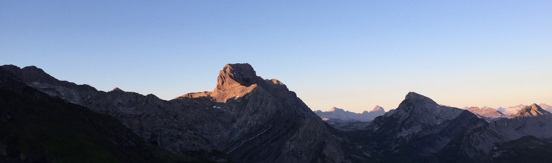 Unter blauem Himmel praesentiert sich der felsige Bös Fulen im goldenen Morgenlicht. Rechts davon ist der Pfannenstock und weiter hinten Gross Ruchen und Gross Windgaellen erkennbar.