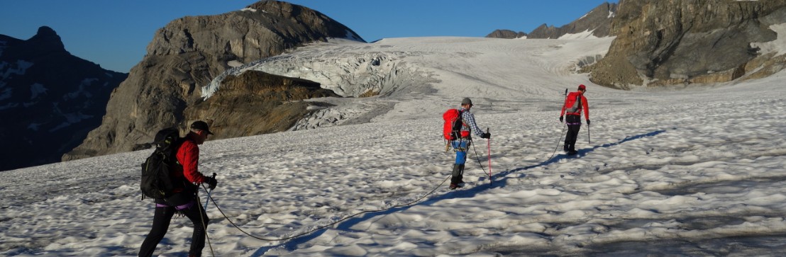 Eine Dreierseilschaft auf dem flachen, sonnenbeschienenen Claridengletscher.