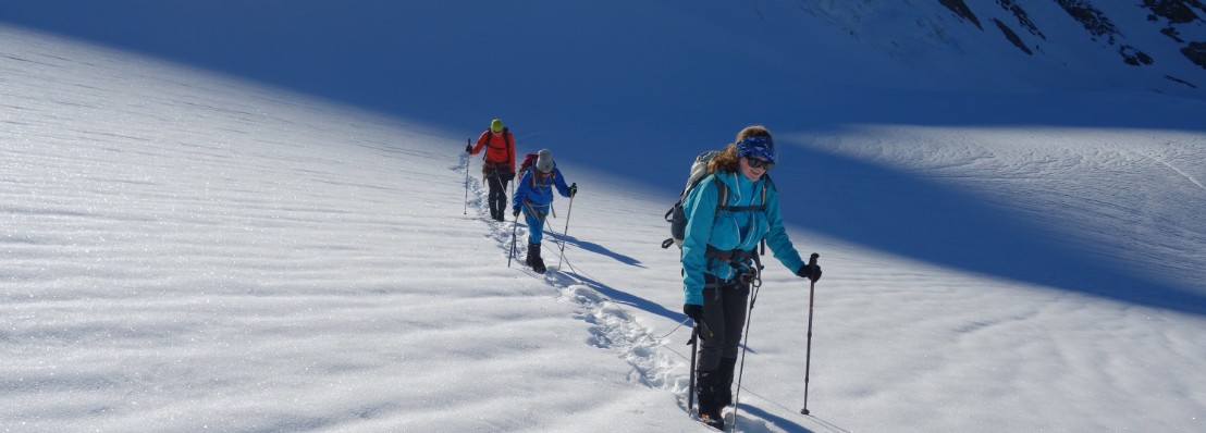 Eine Dreierseilschaft auf dem flachen, sonnenbeschienenen Claridengletscher.
