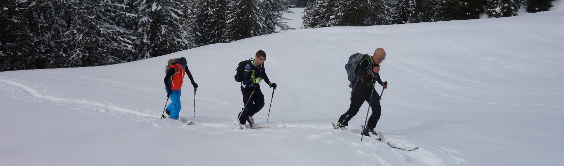 Drei Leute befinden sich hintereinander in der Spur im Aufstieg zum Brueschbuechel