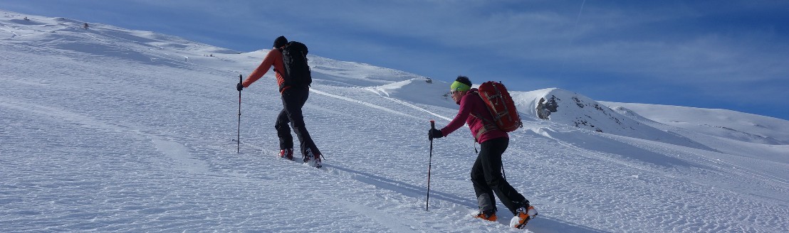 Zwei Personen befinden sich bei sonnigem Wetter im Aufstieg zum Gritlisbord